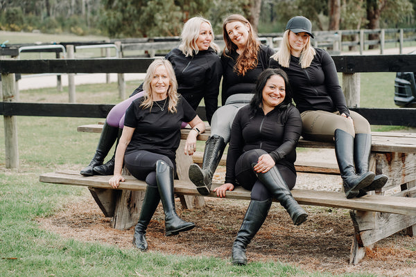 Five women wearing Equicore riding apparel at the stables