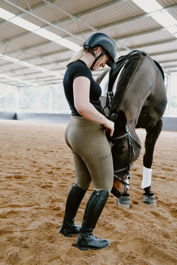 EQUICORE rider standing beside her horse