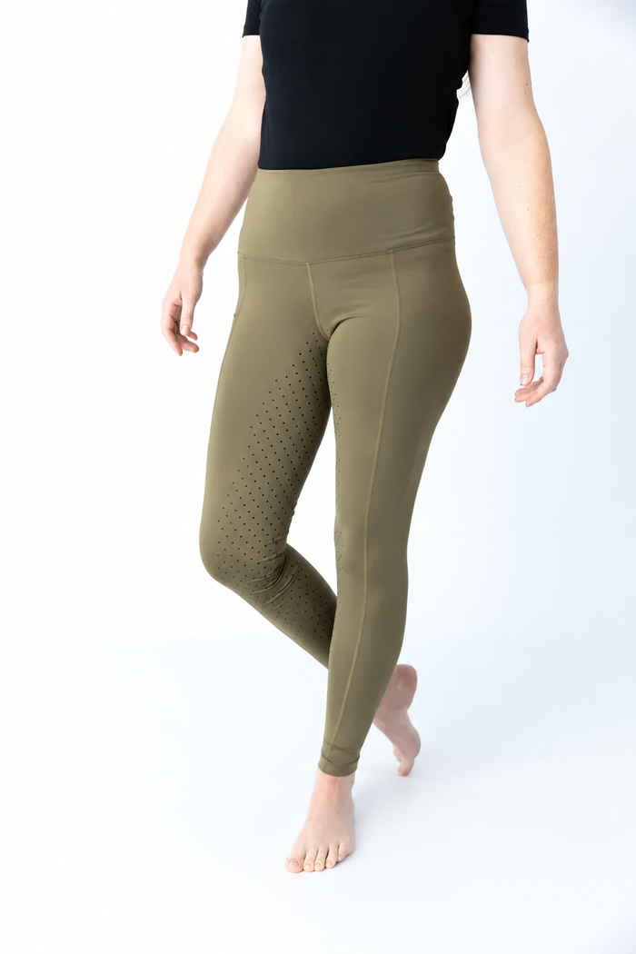 Model wearing olive EQUICORE riding tights showing the high support waistband